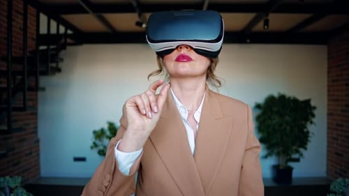 Woman gesturing while using a Virtual Reality headset in an office