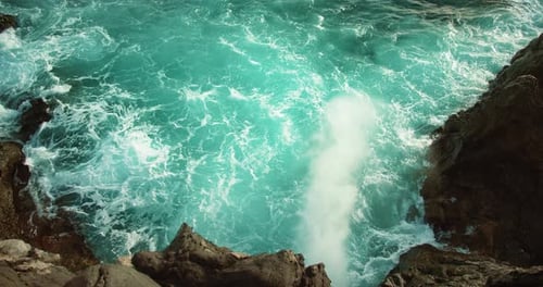Tourquoise Ocean Waves Shooting Up Through a Crevasse in the Rock Slowmotion Sea Water Foaming and