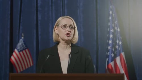 Woman Giving Speech at Podium With American Flags