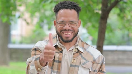 Man with Glasses Gives Thumbs Up in Park