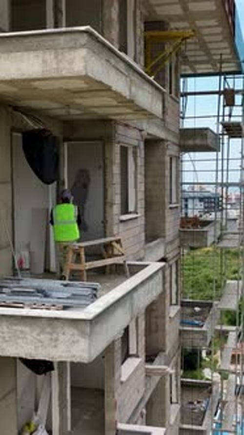 Vídeo vertical: construcción de viviendas, visión aérea de obras de ventanas y fachadas
