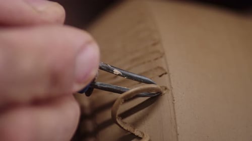 Potter utilise un outil à ruban qui permet de créer un motif sur un vase en argile en gros plan