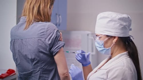 COVID19 Vaccine A Medical Nurse Giving a Vaccine Injection to a Patient in a Clinic The Doctor Uses