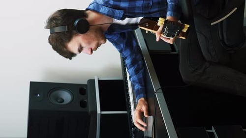 Guitarist playing guitar, recording song in home music studio. Vertical video