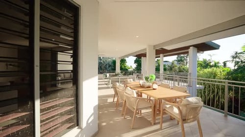 Luxury balcony of a modern home with outdoor seating and a view of the surrounding landscape illumin