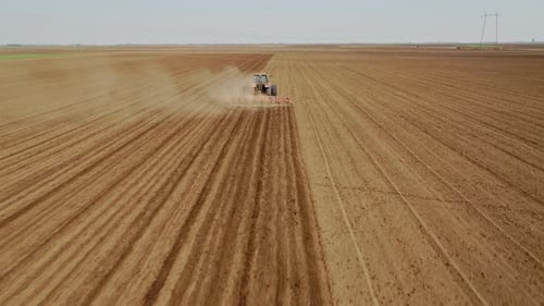 Drone aerial shot of a farmer cultivating arable field