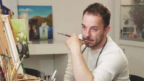 Thoughtful Male Artist Reflecting in His Vibrant Studio