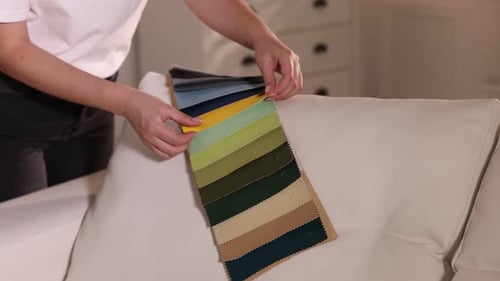 Woman Choosing Fabric Swatches for Couch in Home