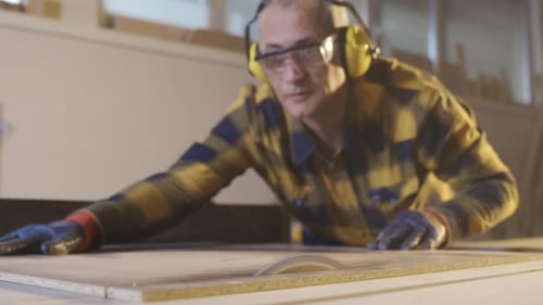 Manufacturer adult carpenter cuts wood in the Carpentry Workshop.
