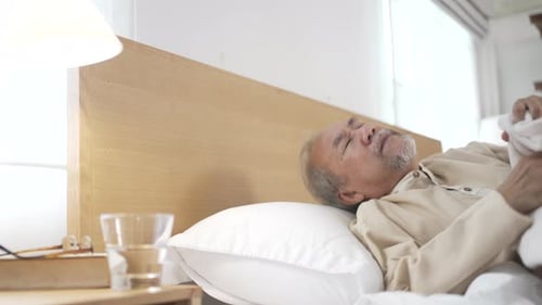 Senior Man Resting in Bed in Bright Room