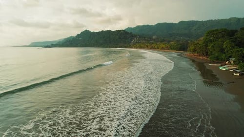 Calm ocean waves rolling at Dominicalito beach during sunset in Costa Rica
