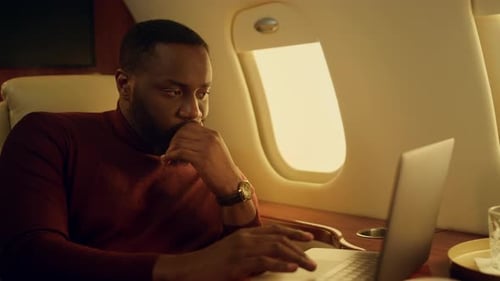 Focused Man Working on Laptop in Private Jet