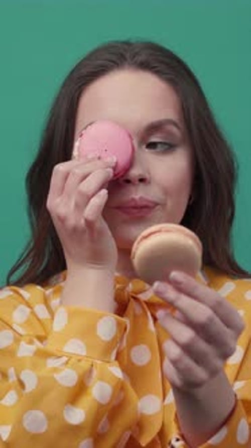 Woman Posing with Macarons Against Blue Backdrop