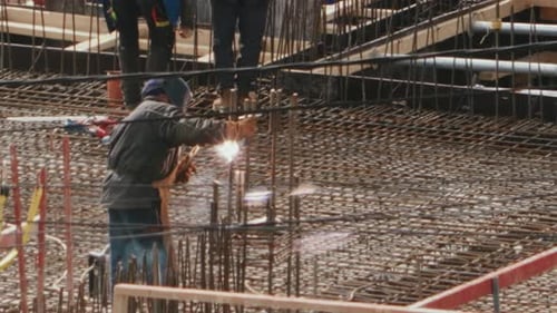 Bauarbeiter schweißt Bewehrungsstahl auf einer Baustelle