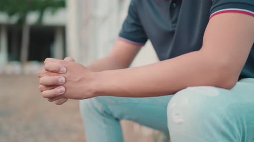 Close-up of a man sitting in the courtyard feeling stressed and suffering from the economic downturn