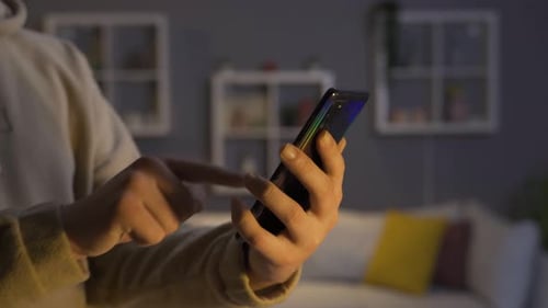 Man Using Smartphone in Lit Living Room