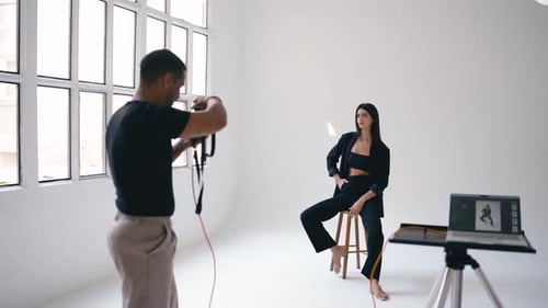 Professional Photographer Taking Pictures of Model in Studio