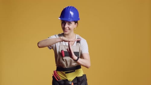 Portrait of Woman Contractor Showing t Shape Sign in Studio