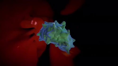 Microscopic view of glowing green and blue cell in red environment