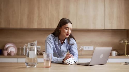 Young Woman Using Laptop with Prosthetic Arm