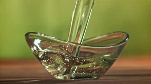 Clear Liquid Pouring into Glass Bowl