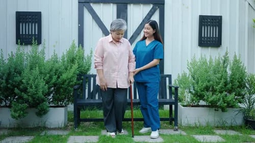 Doctor or nurse caregiver with senior asian woman using walker assistance at home or nursing home