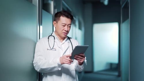 Asian male doctor advise patient remotely using digital tablet. Communicates online talks on video