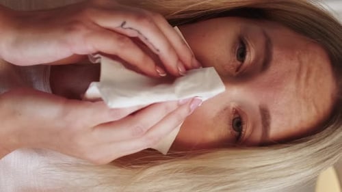 Blonde Woman Blowing Her Nose in Close Up