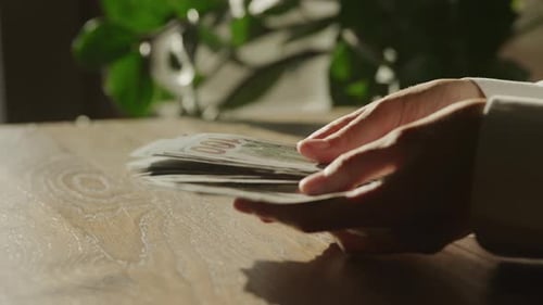 Handheld Close Up of Caucasian Woman Hands Counting Money in 100 Dollar Bill Banknote