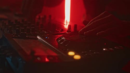 DJ-Hände drehen Schieberegler, während sie Elektronisch Musik im Nachtclub spielen