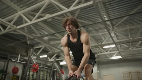 Man Performing Battle Rope Double Waves during High-Intensity Gym Workout