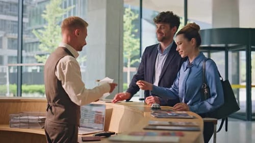 Hotel Guests Paying Contactless with Smartphone Friendly Receptionist Check in