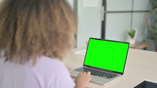 African Woman Using Laptop with Green Screen
