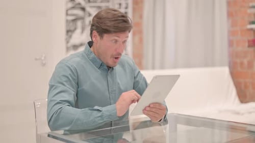 Man Using Tablet Device Gets Frustrated Indoors