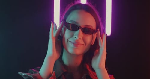Stylish Woman Posing with Neon Lights at Night