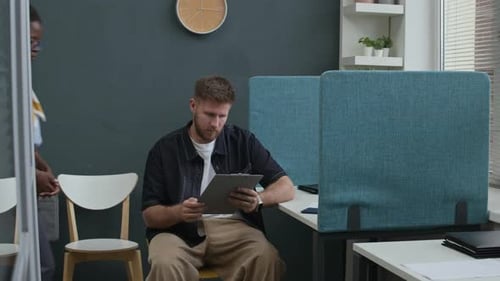 Female Bank Worker Consulting Male Client Reading Agreement in Office
