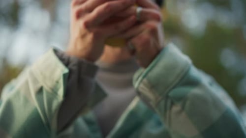 Warm Camping Scene Cozy Autumn Campsite with Mug Man Holds Steaming Mug in Forest Setting Relaxed
