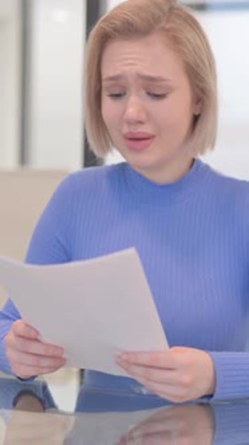 Sad Woman Reading Document in Office Cries