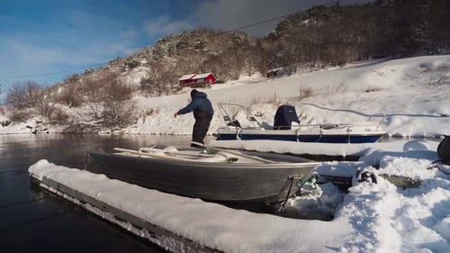 Man Untying Boat On Mooring In The Jetty During Winter. - wide static