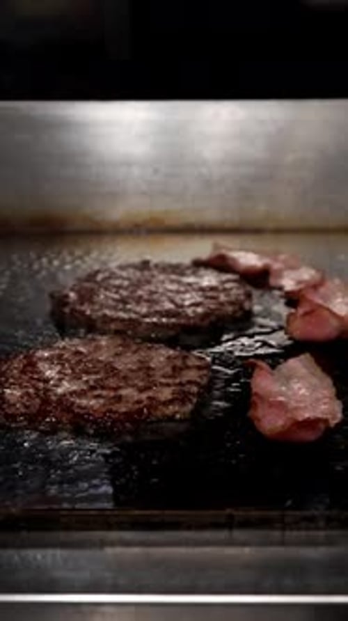 Sizzling Beef Patties and Bacon on a Hot Grill for Burgers