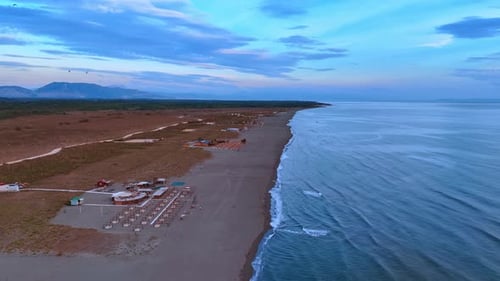 Footage over the beachline at the coast of the Adriatic Sea at dusk time.