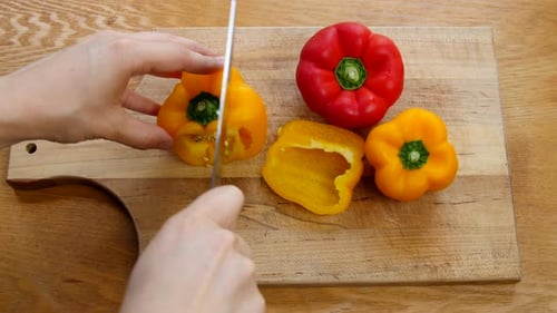 Hands Cutting Yellow Bell Pepper in Kitchen
