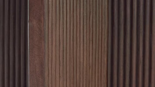 Slow zoom-in on ribbed dark-wood cabinet texture