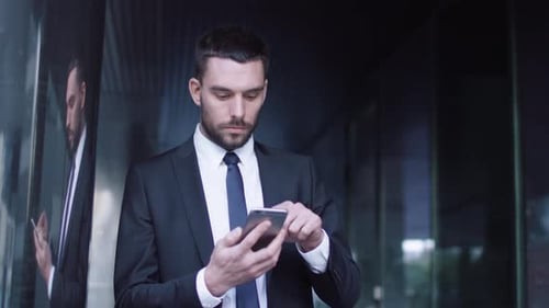 Young Adult Businessman Using Phone in Urban Setting