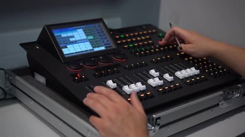 Hands Operate Audio Mixing Console at Workplace