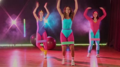 Women in 80s Outfits Exercising with Resistance Bands