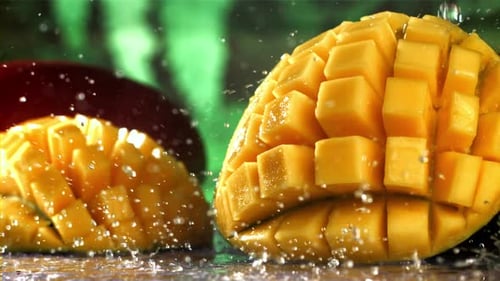 Fresh Mango Slices Splashed with Water Close Up