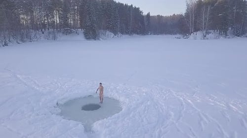Man Takes Winter Ice Bath in Snowy Landscape
