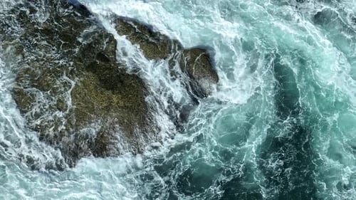 Powerful ocean waves crashing on rocky coastline.