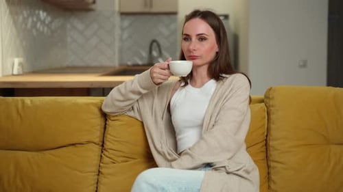 Young Adult Woman Relaxing with Coffee at Home